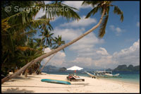 Tourists resting in hammocks on the island of Pangulasian. Palawan.