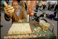 Además, la llamada desde los altavoces a los sucesivos oficios religiosos de las varias mezquitas que se distribuyen por la Plaza Jemaa El Fna de Marrakech provocan un constante movimiento de feligreses por élla. Cuando paseas por la plaza a lo largo del día, te mueves bajo el sonido de la flauta de los encantadores de serpientes. O entre amaestradores de monos y otros personajes exóticos como los aguadores o los vendedores de dentaduras postizas.