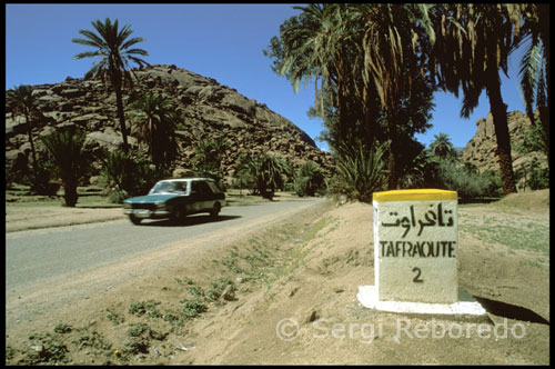 Tafraoute. El Anti Atlas, sigue siendo una de las zonas montañosas menos visitadas del país. Las montañas son el bastión de las tribus chleuh, estas viven en una especie de confederación de pueblos diseminados por las áridas montañas, algunos de ellos escapan por completo al alcance del poder central. Los franceses no pacificaron la región hasta 1930.    Los Chleuh, amoldados al áspero y granítico terreno de coladas de lava, siempre se han dedicado a sus granjas situadas en los oasis, actualmente los palmerales mas hermosos de Marruecos.    Tafraoute con sus 5.000 habitantes se halla en el precioso valle de Ameln, completamente rodeado de montañas de granito rojo, su aspecto es humilde pero la zona es bastante prospera gracias al dinero de la emigración de sus habitantes. Esta población es el lugar ideal para empezar cualquier excursión a las montañas del Anti Atlas.    Entre febrero y marzo, los pueblos de los alrededores celebran la fiesta de ra recogida de la almendra con danzas y cantos que duran toda la noche, estas fiestas se trasladan de pueblo a pueblo, por lo que duran varios días. Un animado mercado se celebra cerca del Hotel Salama desde el lunes por la tarde hasta el miércoles.    Tafroute es el lugar perfecto para la experiencia de los hammams (baños árabes), ya que la mayoría de las casas del pueblo no tienen agua corriente, hay tres, los vecinos frecuentan el mas antiguo detrás del mercado, los tres cuestan 10 Dh.    También en la población hay ofertas para los excursionistas, aunque la mayor parte son extenuantes, existen varias empresas. No muy alejado de la población también podemos ver grabados prehistóricos, pero lo mas interesante se halla a 3 Km. de Tafraoute, concretamente en Aguerd-Oudad, se puede llegar paseando o en bicicleta, pasaremos por una formación rocosa con el nombre de Chapeau de Napoleón (el sombrero de Napoleón), se debe seguir el camino marcado a través del pueblo, se rodea la mezquita y seguimos la pista hasta el río y después seguir por el llano, a 1,5 Km. se podrán ver a la izquierda unas rocas de color azul, las Perres Belues (piedras pintadas), obra de Jean Verane; artista belga pinto a spray las rocas redondeadas con diferentes tonos de azul, rojo, púrpura y negro en 1984, están algo descoloridas pero siguen siendo impresionantes. Cómo llegar Las principales compañías de autobuses parten de Sharia al-Jeish al-Malaki. Entre sus destinos más importantes figuran: Casablanca (14 horas), Rabat (16 horas), Tiznit (3 horas), Agadir (5 horas) y Marrakech (10 horas).  Dos autobuses locales tienen salidas hacia Tiznit a las 4:00 y a las 7:00. Marruecos cuenta con un sistema de autobuses rápido y económico que conecta las principales urbes así como una compañía aérea, Air Maroc, que ofrece vuelos internos entre las principales ciudades del país. La línea férrea sólo cubre la parte norte del país.  