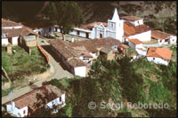 Església i voltants. Els Nevats. Veneçuela. Diversos excursionistes que tornen de retorn es creuen en el meu camí. Van proveïts de cavalls o mules, ja que, tant a peu del funicular com al poble, és possible llogar-si no tenim la forma física adequada per a aquesta caminada de cinc hores. El paisatge muntanyós em captiva per la seva aclaparadora bellesa, en la qual destaca sobretot el contrast del color rogenc de l'erm amb groc dels frailejones. Aquesta planta típica andina, de flor semblant a la margarida, és de la família de les compostes i floreix cap al mes de setembre inundant l'erm d'un color daurat intens. El camí és llarg i travessa diversos rierols que transporten les gèlides aigües de les muntanyes properes cap a les planes.