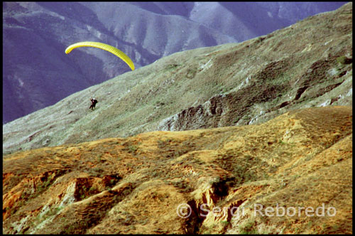 Algunos aficionados se acercan para ver volar los parapentes.  Parapente en Tierra Negra.  Venezuela. Uno a uno los parapentes fueron descendiendo por el valle. La suavidad con que planeaban era asombrosa. Los curiosos se habían colocado en lugares estratégicos de la ladera desde donde se podía divisar todo el espectáculo. Algunas familias estaban al completo, y sus hijos de corta edad eran los que más disfrutaban, eso sí, sin acabar de entender todas las explicaciones que sus padres les estaban dando sobre como un hombre podía mantenerse en el cielo tanto rato sin llegar a caerse. Para las gentes de Mérida este idílico paraje resultaba un lugar cautivador donde poder pasar el rato unidos merendando, mientras las vistas iban cambiando minuto a minuto como si de una película se tratase. La indumentaria de los artistas de este deporte impresionaba sobremanera. Los monos multicolor conjuntaban perfectamente con el color de las telas de sus velas. El casco cubría totalmente sus cabezas, dejando al descubierto únicamente la circunferencia de sus ojos. Era de lo más parecido a los astronautas que salen al espacio. La explicación era lógica, por una parte el casco era un elemento clave para la seguridad y, por otra parte, el mono amortiguaba el viento y las frías temperaturas en el aire. De repente me vi ataviado con un casco negro en la cabeza, un arnés y atado mediante varias cuerdas con mosquetones a Oswaldo. La tensión era extrema. El parapente, que era de un color amarillo limón, ya estaba totalmente desplegado. Sus extremos se movían con virulencia, como si tuviesen prisa por empezar a volar.    Tierra Negra es una planicie  donde no solo venezolanos viajan para vivir esta experiencia, sino que personas de otros países disfrutan al máximo del lugar, la vista y  sobre todo para cumplir el sueño de volar.  A unos 40 minutos de la ciudad de Mérida se encuentra un lugar muy atractivo denominado Tierra Negra. Dicho asentamiento es una zona árida, rodeada de montañas, con una vista privilegiada y vientos que están a la espera de los cientos de parapentes guiados por expertos profesionales y por aquellos que quieren vivir esta experiencia.