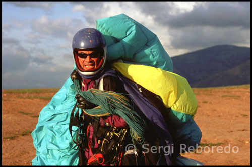 Monitor para vuelos en tandem. Parapente en Tierra Negra. Venezuela.  El viento soplaba con fuerza, o eso era lo que a mi me parecía. Al menos seis personas nos sujetaban a tierra firme para que no pudiéramos salir volando en un momento inapropiado. Mientras, el aire intentaba arrancarnos del suelo para llevarnos junto a él.     “Ya te puedes sentar y ponerte cómodo” me dijo Oswaldo, “el despegue ha sido todo un éxito”. El cielo estaba cada vez más borracho de nubes y yo me afianzaba con fuerza a las cuerdas. Las vistas desde allá arriba eran todavía más espléndidas que desde donde habíamos iniciado el vuelo. Entrábamos y salíamos de las nubes como si de un espejismo se tratara.   Mientras planeábamos por el aire otros parapentes se cruzaban en nuestro camino, era como si se tratase de una carretera aérea. Me sentía embrujado por el entorno y aquella sensación de pavor que había tenido momentos antes del despegue se había convertido en fascinación y admiración. No tenía ganas de descender, juro que me hubiese quedado horas y horas imitando el vuelo de las aves en ese poético cielo venezolano.  A unos 40 minutos de la ciudad de Mérida se encuentra un lugar muy atractivo denominado Tierra Negra. Dicho asentamiento es una zona árida, rodeada de montañas, con una vista privilegiada y vientos que están a la espera de los cientos de parapentes guiados por expertos profesionales y por aquellos que quieren vivir esta experiencia. Mérida ha tomado el carácter de ser la capital del parapente en Venezuela, debido al historial que  tiene Tierra Negra y  el  clima, el cual permite  los vuelos todos los días del año de una manera segura y gratificante.