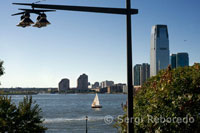 Battery Park City. A large green area with a promenade along the Hudson River, beginning at the southern tip of Tribeca, in Rockefeller Park and extends to the Ferry Terminal on Staten Island, sharing the stage with modern buildings in which live the jet-set New York. The photo shows a sailing boat around the bay and some buildings at the back of Jersey.