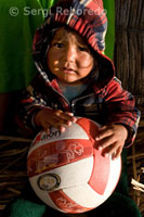 Una niña en la isla de Los Uros ubicada en el interior del Lago Titicaca juegan con una pelota de volley. 