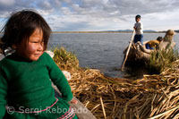 Unos niños navegan en una barca de totora por el Lago Titicaca cerca de una isla habitada por Uros. 