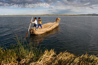Unos niños navegan en una barca de totora por el Lago Titicaca cerca de una isla habitada por Uros. 
