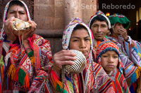The people of the mountain, dressed in traditional costumes at the door of the church of Pisac Sunday market day. Pisac. Sacred Valley. SING OF PERU CUZCO