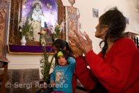 A woman praying in the church of Pisac Sunday market day. Pisac. Sacred Valley.