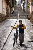 A child on a bike in the steep streets of the village of Chinchero in the Sacred Valley near Cuzco.
