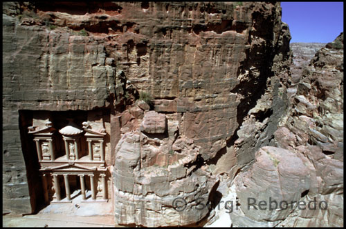 Sin duda el punto central de una visita a Jordania es Petra. Pero como ocurre, por ejemplo, con las óperas, a veces la obertura impresiona más que la trama central. Así ocurre en cierto modo en Petra. Tras la entrada principal, y después de sortear o aceptar a los chavales que ofrecen hacer el recorrido en burro, caballo o calesa, el visitante llega al comienzo del impresionante "Siq", que al principio parece un corto paso entre rocas y pronto se descubre como una inmensa grieta en la piedra de arenisca que se abre a lo largo de un kilómetro y medio entre profundos acantilados que en ocasiones ofrecen 200 metros de altura por sólo cuatro de ancho.  Este es el camino hacia el Tesoro, la senda permitida dentro del gran parque nacional que es Petra. La Policía del Desierto, con sus túnicas verde caqui, sus fajines, los cuchillos al cinto y los fusiles al hombro, se encargan de disuadir a los visitantes aventureros de acampar en las montañas, como hasta hace poco solían hacer. Lo que los turistas llaman Petra, es una fracción --la más espectacular-- de un área de 264 kilómetros cuadrados, Parque Arqueológico Nacional desde 1993. 