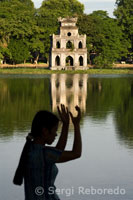 Haciendo ejercicio matutino en el lago Hoan Kiem junto al Thap Rua (torre de la Tortuga). Barrio Antiguo de Hanoi.