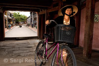 Una bicicleta pasando por el puente cubierto japonés, emblema de la ciudad de Hoi An.